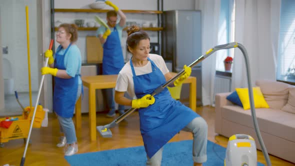 Team of Young Cleaning Service Professionals Having Fun Working in Apartment