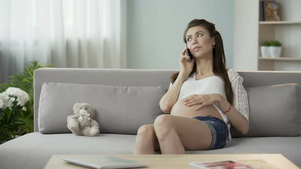 Pregnant Woman Having Conversation Over Mobile Phone, Looking Worried, Insecure