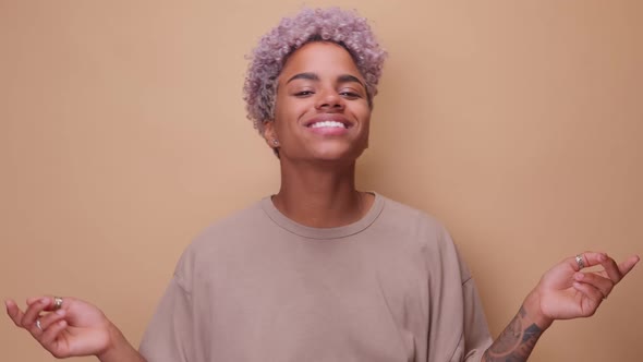 Joyful Young African American Woman Dances Broadly Smiling and Winking