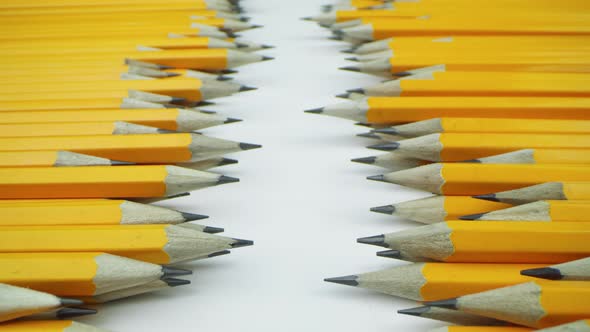 Yellow Pencils Randomly Lie on a White Background