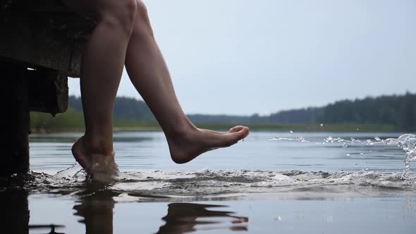 Woman Feet Playfully Splashing Lake Water Enjoying Her Time. Lake Holidays. Self Care Concept. 