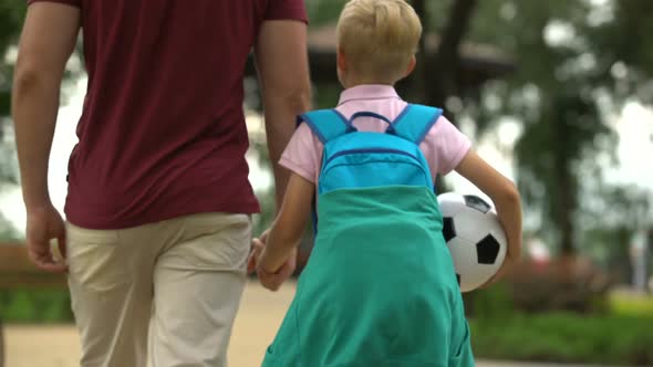 Father Walking Home With Son After School, Discussing Sport Classes, Football