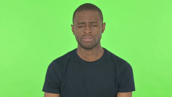 Sad Young African Man on Green Background