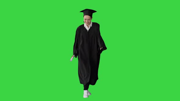 Young Graduated Woman Dancing and Having Fun While Walking on a Green Screen, Chroma Key.