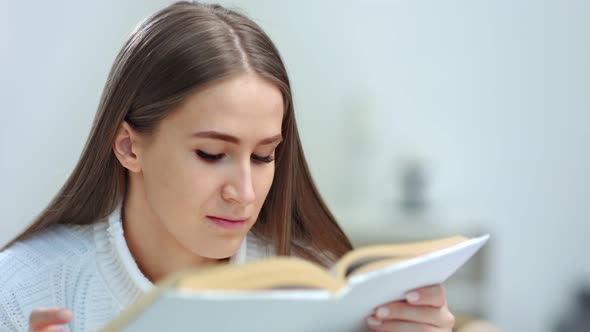 Closeup Face of Enthusiastic Young Woman Reading Interesting Book