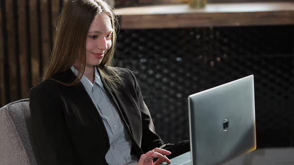 Confident Businesswoman Working on a Laptop in Her Modern Blue Modern Office Interior. Stylish