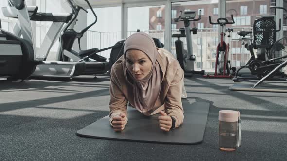 Woman in Hijab Doing Plank in Gym