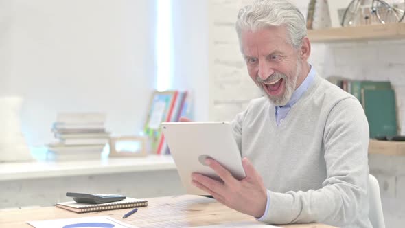 Old Man Excited for Results on Tablet