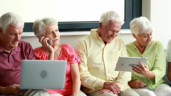 Senior citizens using digital tablet and laptop