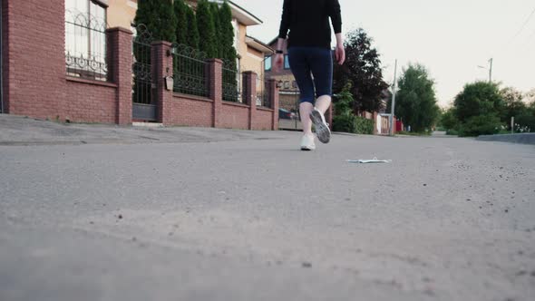 Close Up Woman Legs Running on Concrete Footpath at Public Park with Sunlight in the Background