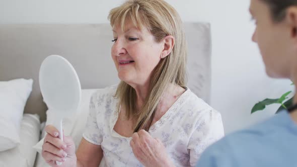 Senior woman touching her hair looking in the mirror