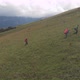 Aerial Shot of a Group of Tourists with Backpacks Climb the Mountain - VideoHive Item for Sale