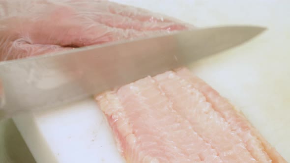 Chef cutting raw white fish, close-up.Preparing the fish meat to be cooked.