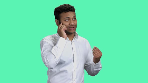 Businessman Talking on Glass Phone Against Color Background