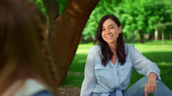 Smiling Woman Sitting on Grass in Park Closeup