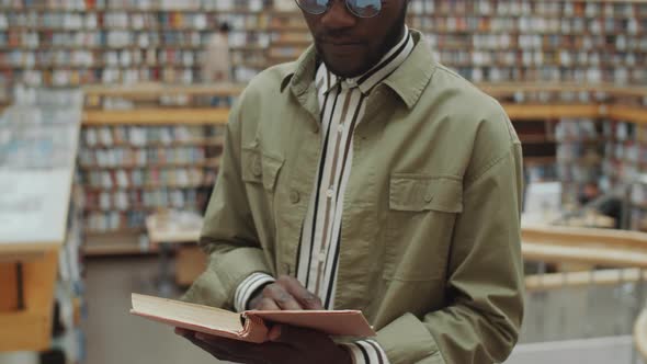 Black Man Reading Book in Library