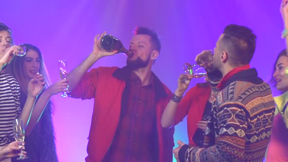 Friends Holding Champagne Enjoying Party . Smoke Background. Slow Motion