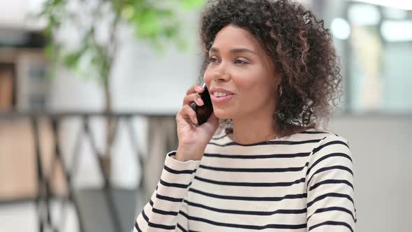 Close Up of Young African Woman Talking on Smartphone