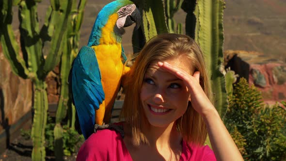 Yellow-Blue Parrot Sits on Blonde Models Shoulder on a Sunny Day