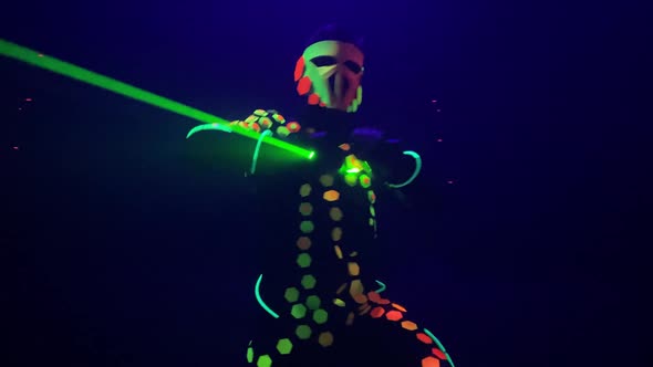 Person in Glowing Suit Dances with Green Beams on Stage