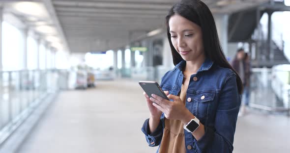 Woman looking at cellphone in airport