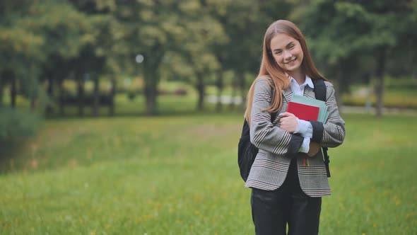 A Smiling Student with Books in the Park