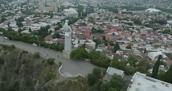 Dolly in drone shot of the back of Kartlis Deda monument and the Tbilisi.