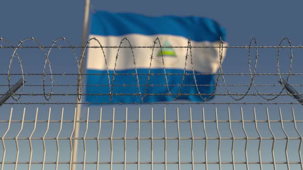 Waving Flag of Nicaragua Behind Barbed Wire