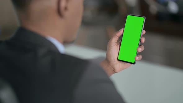 Rear View of African Businessman using Smartphone with Chroma Screen