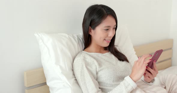 Young woman use of mobile phone on bed