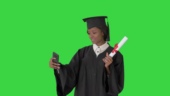 Smiling African American Female Graduate Making Selfie with Diploma on a Green Screen Chroma Key