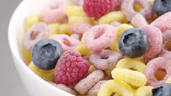 Milk Flow Pouring Into Bowl with Cereal Rings and Berries