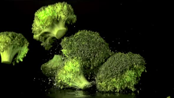 Super Slow Motion Broccoli Falls on the Table with Splashes of Water