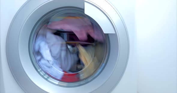 Close Up Industrial Washing Machine Washes Colored Clothing and White Linen, White Striped Clothing
