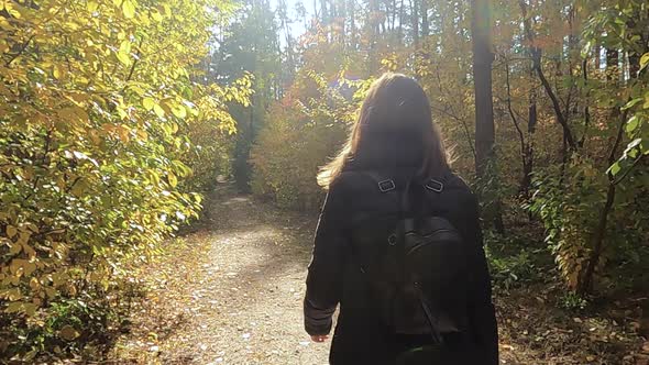 The Girl Walks Through the Autumn Forest