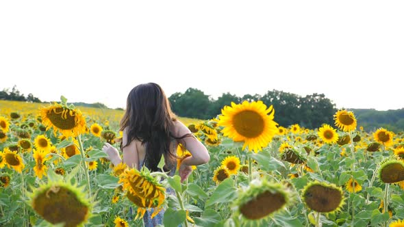 Happy Carefree Girl Running Through Sunflower Field