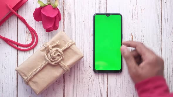 Top View of Man Using Smart Phone and Gifts on Table 