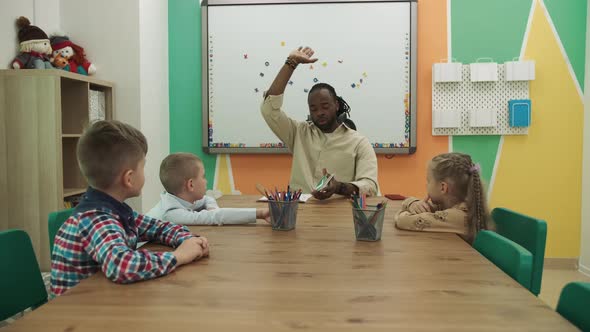 African American Teacher and Students Study Numbers in the Classroom