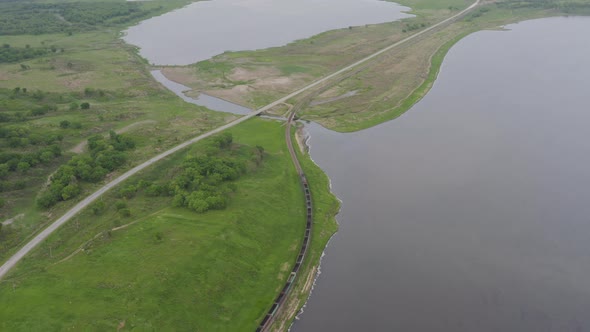 A Drone View of a Freight Train Driven By a Diesel Locomotive on a Railroad