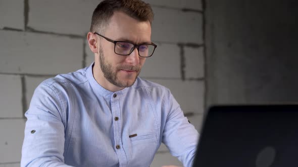 Handsome businessman with glasses working at computer in office