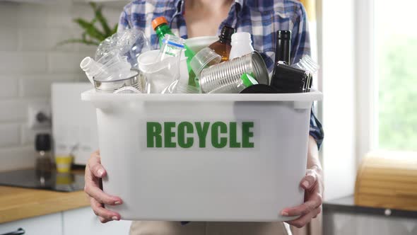 Young Woman is Holding Basket with Garbage in Hands While Standing at Home