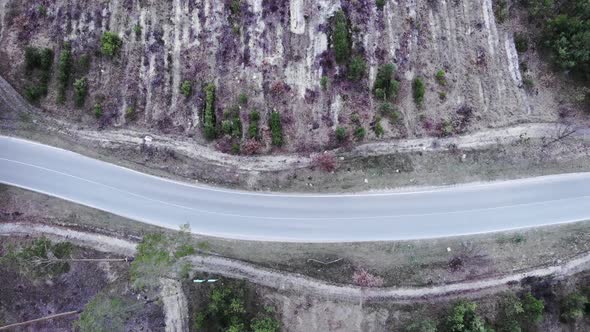 Motivated triathlete riding on empty car road in forest. Isolated cycling. Triathlon and cycling