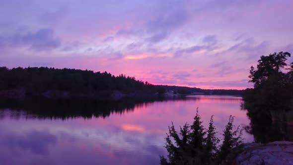 Moving towards a lake, at purple sky, colorful sunset or dusk, at Albysjon, Tyreso, Sweden