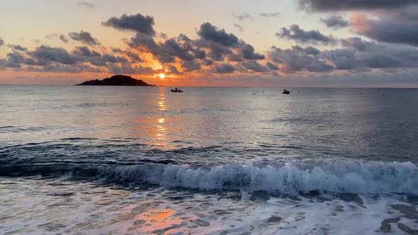 sea at orange dawn with a small island on the horizon