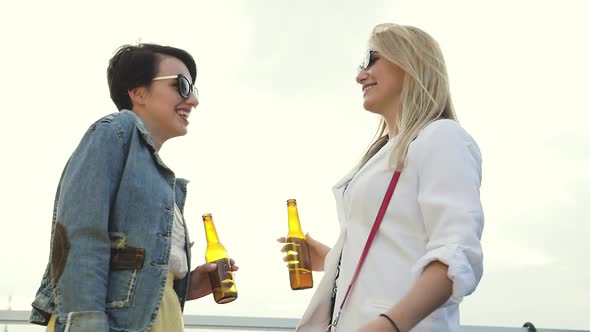 Smiling Women Having Fun, Drinking Beer And Dancing Outdoors