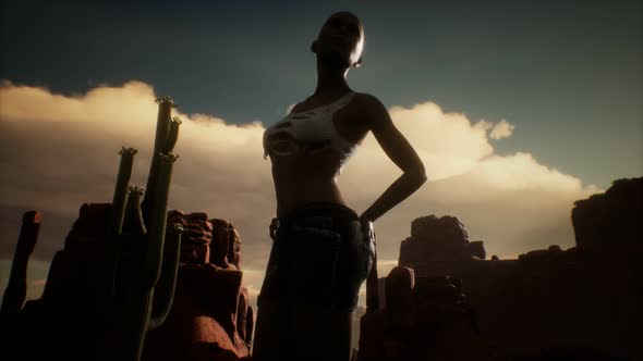 Woman in Torn Shirt Standing By Cactus in Desert at Sunset