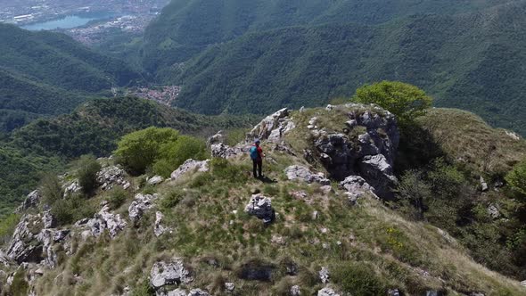 Hiker on top of mountain peak, European Alps, Lecco, Italy