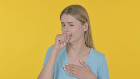 Young Woman Coughing on Yellow Background