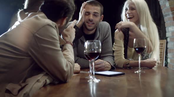 Group of Friends Makes a Toast Smiles and Drinks Wine in Rural Farm House Tuscany Italy at Night