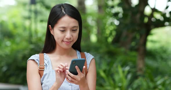 Woman look at cellphone with the background of green plant